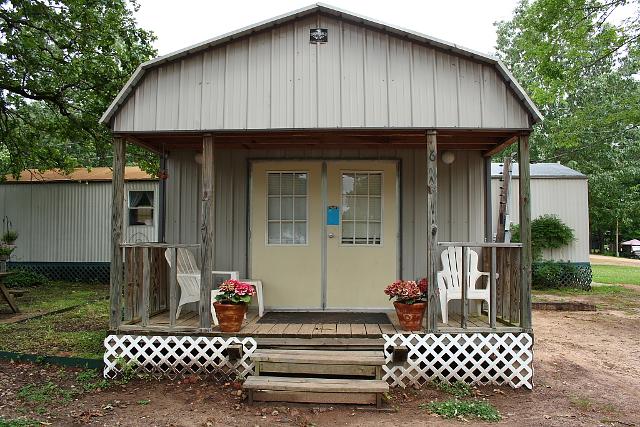 Small Cabin Featuring A Porch With Two Chairs