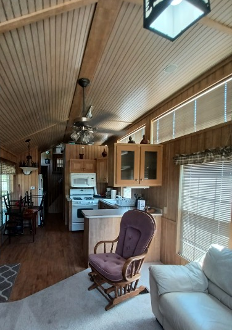 A Cozy Cabin Interior Featuring A Living Room With A Sofa And A Kitchen Area
