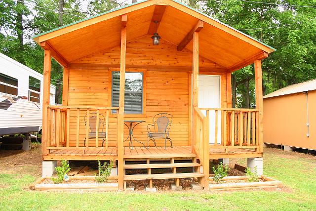 small cabin featuring a porch and a deck