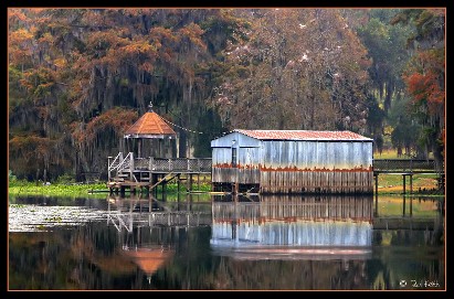 Small Wooden House Located On The Tranquil Shore Of A Lake