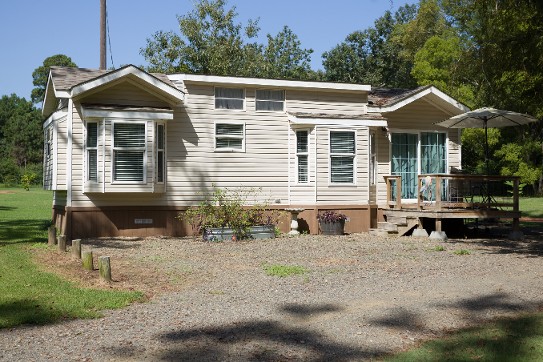 A Small House Featuring A Porch And A Deck