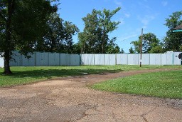 Dirt Road Flanked By A Wooden Fence